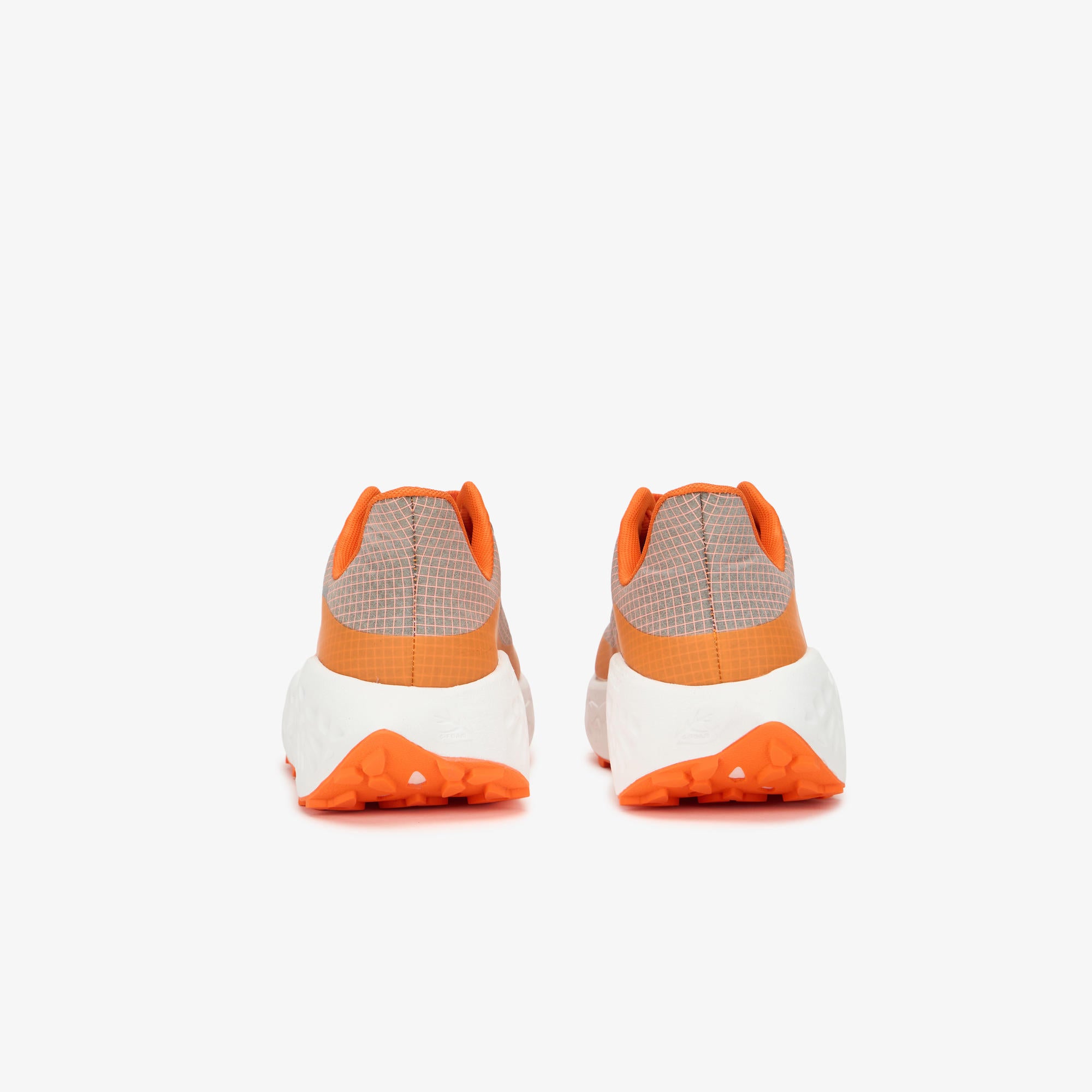 A pair of ULYSSES MAIKOH sneakers shown from the back, featuring a beige and white checkered upper, a bright orange midsole band, and an orange outsole.