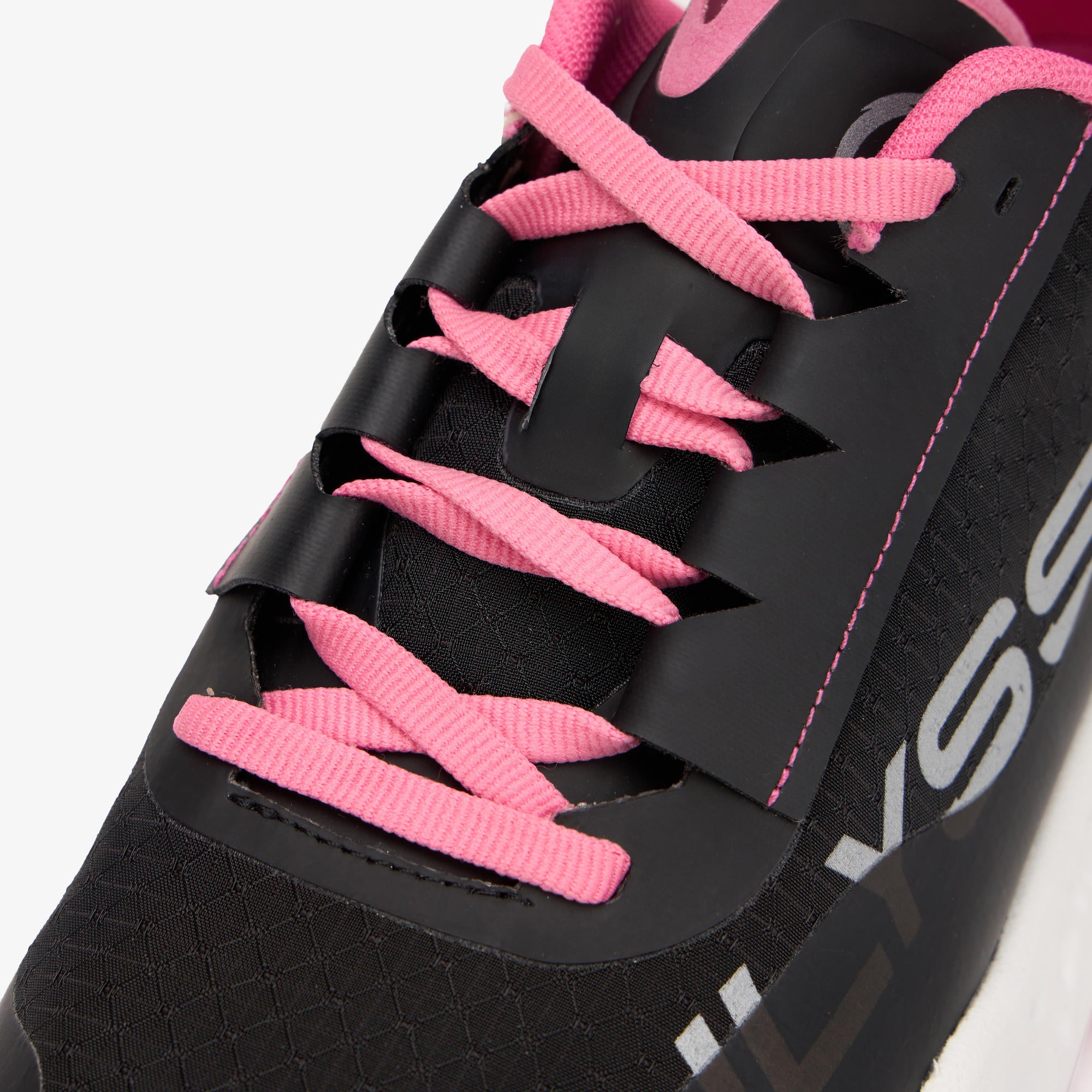 Close-up of a black ULYSSES MAIKOH shoe with bright pink laces and pink stitching details, showing part of the white brand lettering on the side.