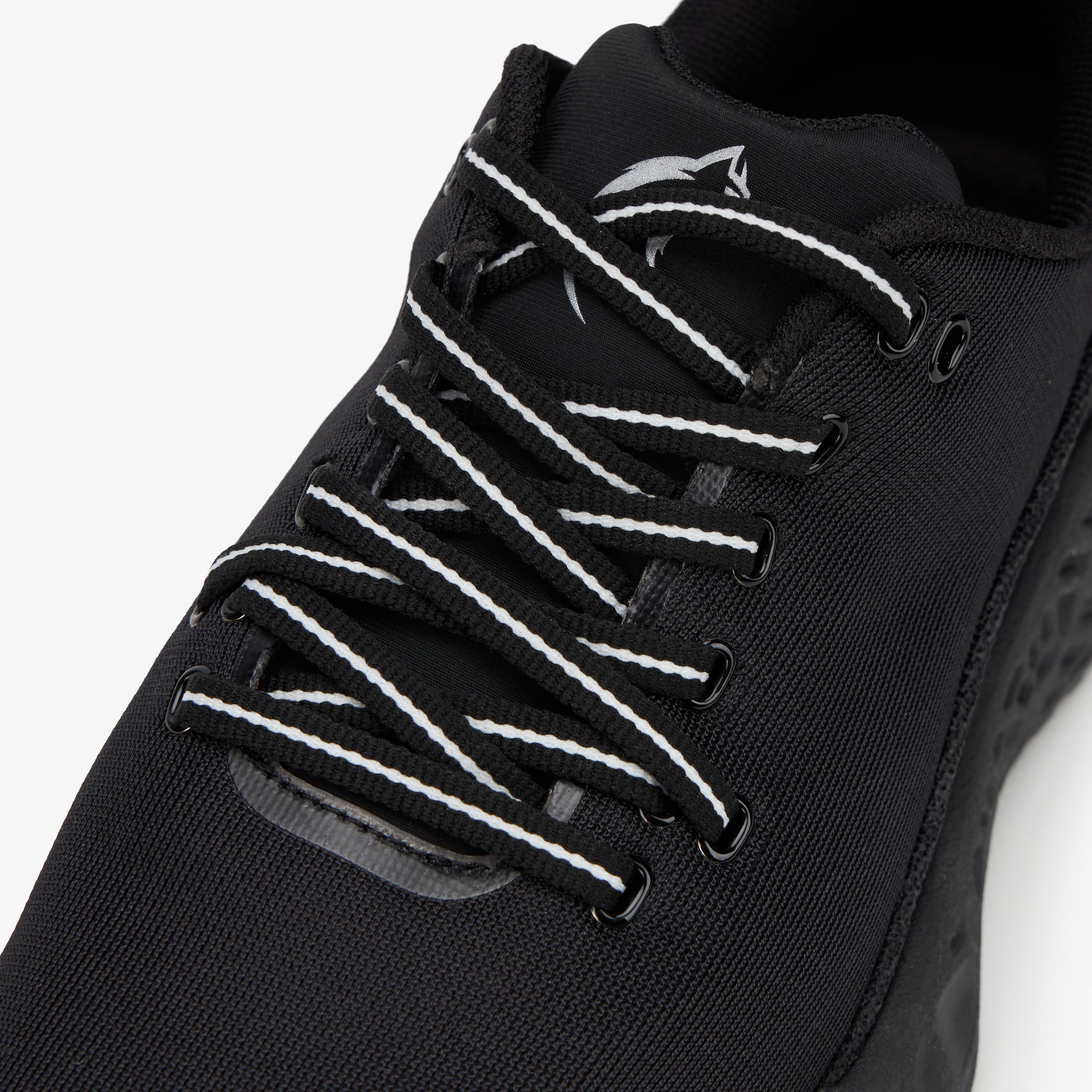 Close-up of a black ULYSSES NAAKII  shoe with white contrast laces and a white shark logo on the tongue, set against a plain white background.