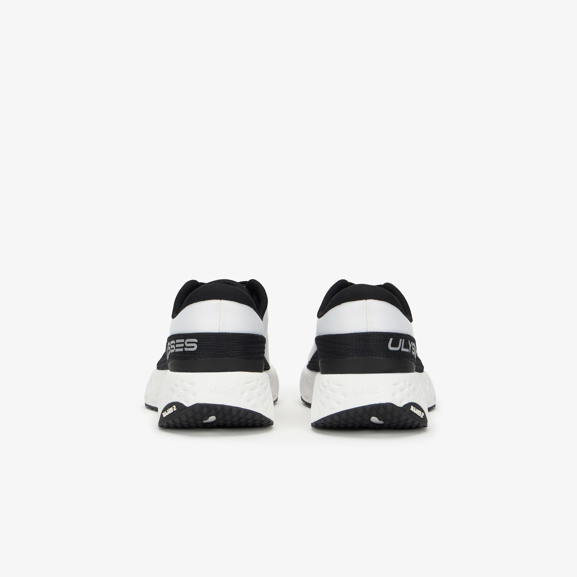 A pair of black and white running shoes shown from the rear, featuring a thick white midsole and black heel sections with white branding text.