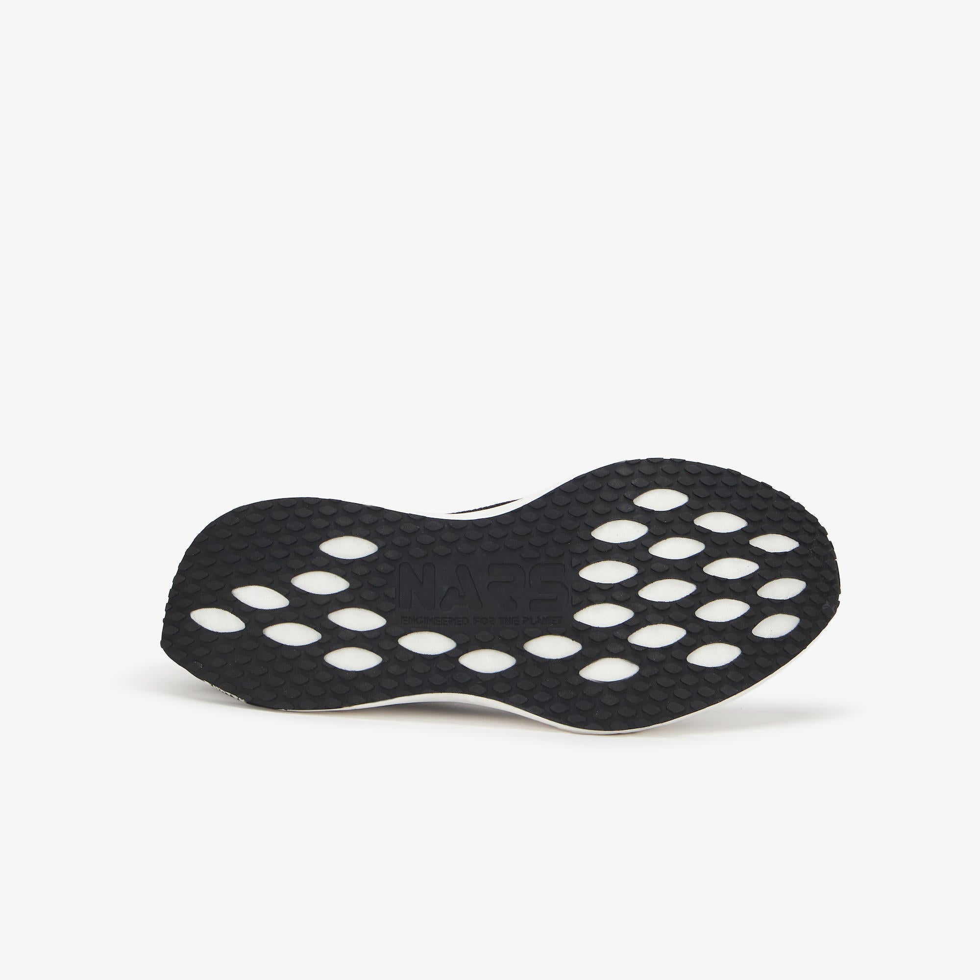 The black textured outsole of a sneaker, featuring a pattern of circular cutouts, shown from a side profile view against a light gray background.