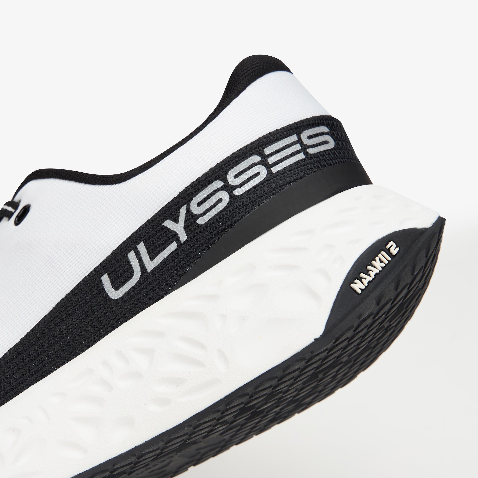 Close-up of a white and black running shoe showing the heel area with 'ULYSSES' branding on the side and 'NAAKII 2' on the outsole.