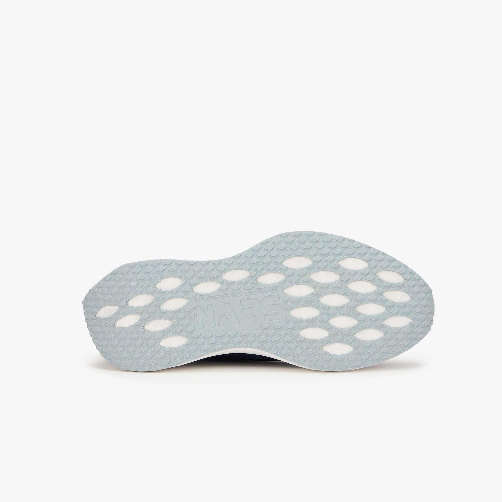 A light blue-gray shoe insole with a textured honeycomb pattern and circular cutouts