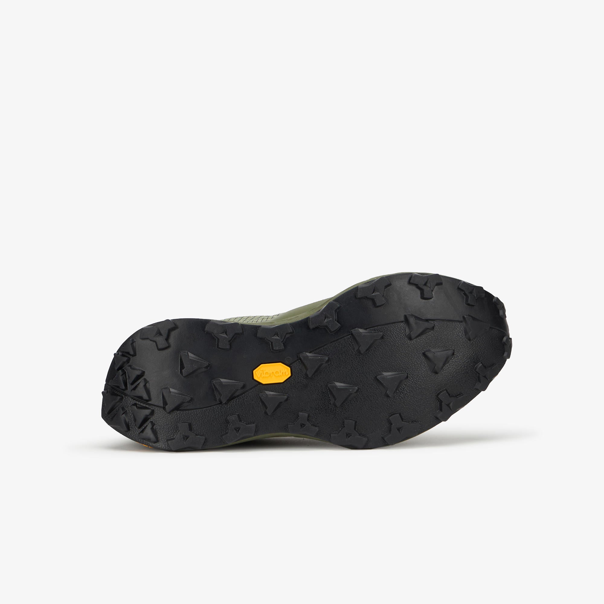 The black Vibram outsole of a hiking shoe, showing the deep lugs and a small yellow Vibram logo, photographed from underneath against a light gray background.
