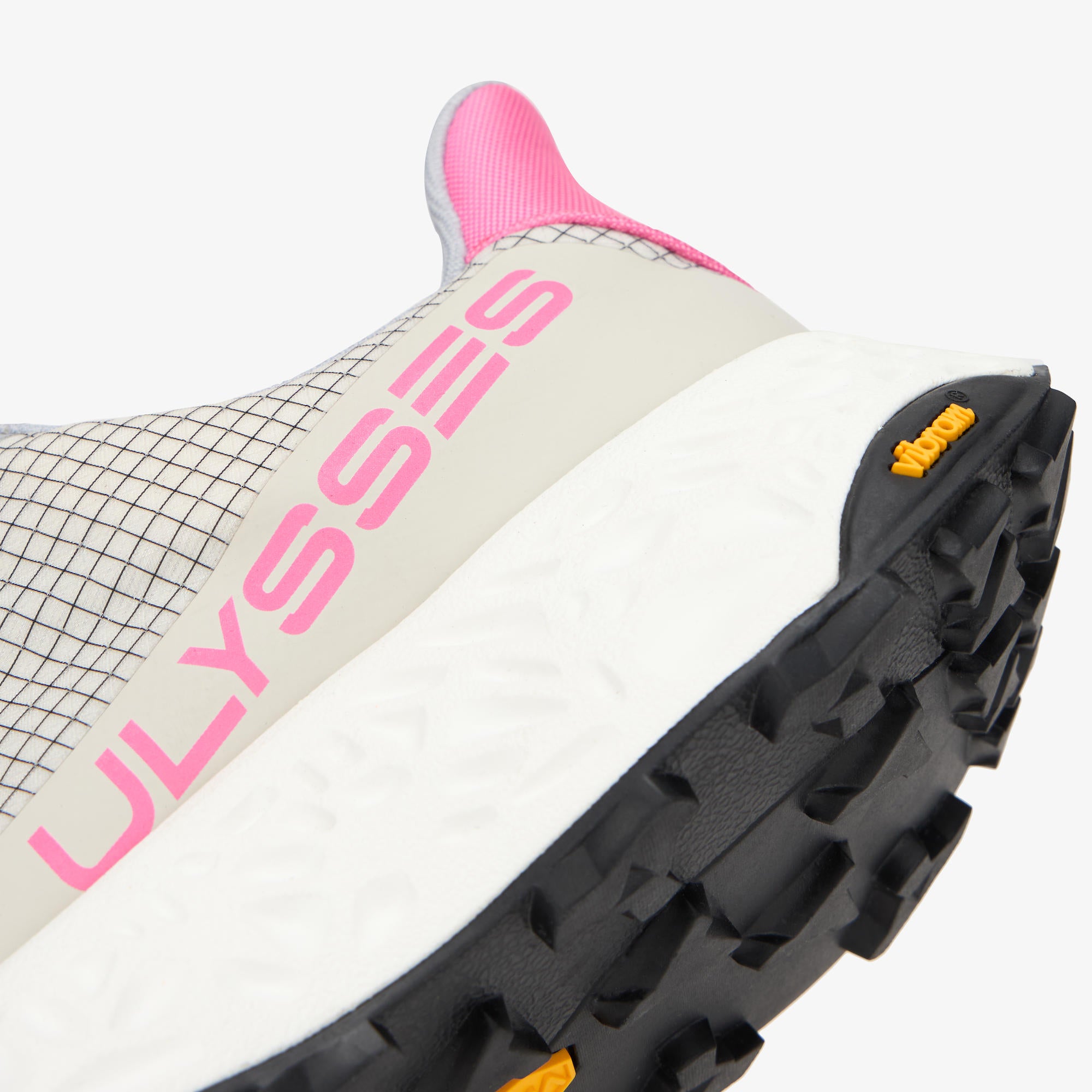 Close-up of a running shoe showing the side panel with large pink 'ULYSSSES' branding, a white midsole, black outsole, pink heel collar, and small yellow Vibram logo on a light gray background.
