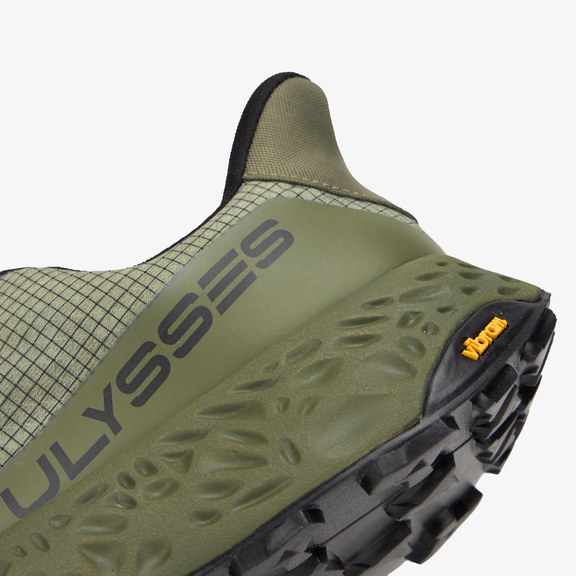 Close-up of the heel and midsole of a green Vibram ULYSSES NANUK trail running shoe, showing the textured olive green outsole, black heel cap, and the Vibram logo.