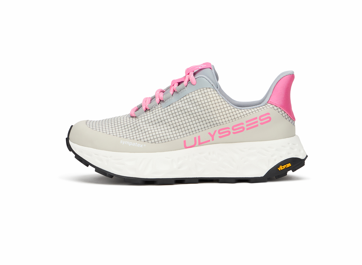 Product shot of a beige and gray Ulysses trail shoe with pink accents and a Vibram outsole, side view on a white background.